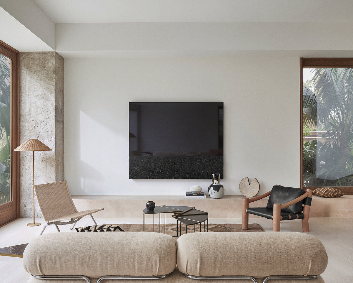 FITUEYES ZEN TM65 Fabric TV mount above a coffee table in a living room with cream sofas and a lounge chair