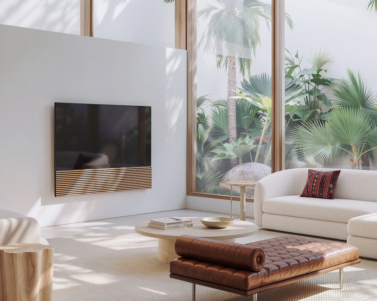 FITUEYES ZEN TM65 Grille TV mount on a living room wall beside a sofa, woven coffee table and large window