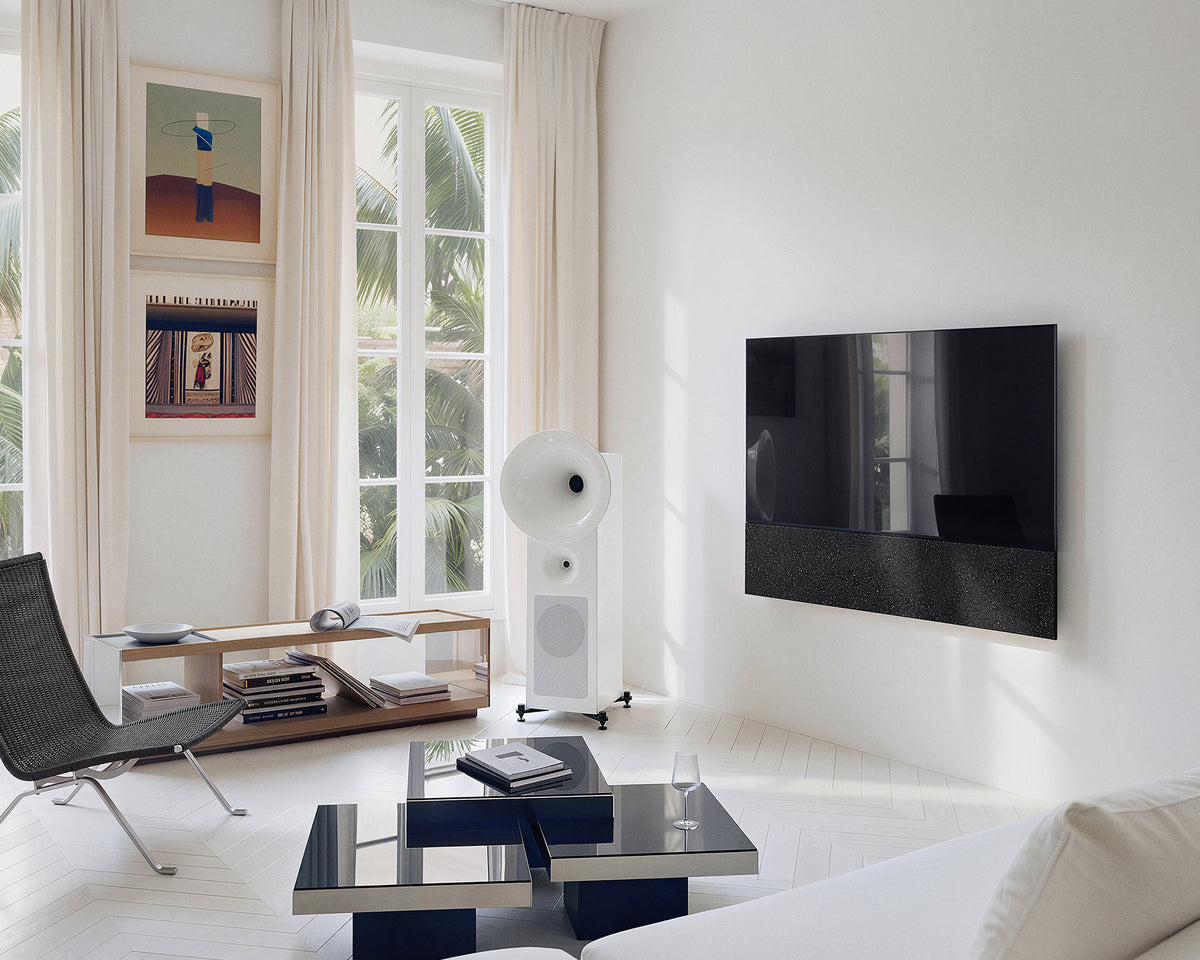 FITUEYES ZEN TM75 Fabric TV mount in a bright listening room with white speakers and a glass coffee table