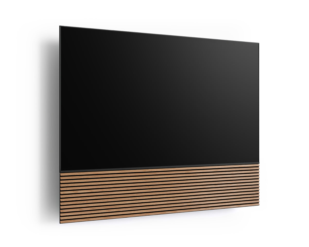 Angled front view of the FITUEYES ZEN TM75 Grille TV mount with a TV and wood-slat panel on a white background